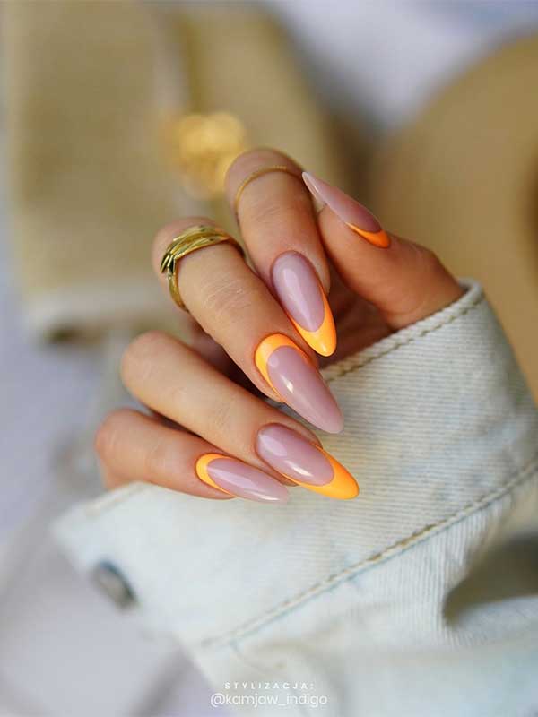 Long almond light orange French manicure features reverse French nails with two accent French tips
