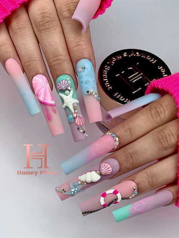 Long square shaped under the sea nails with matte pastel blue-pink ombre effect, snails, and rhinestones