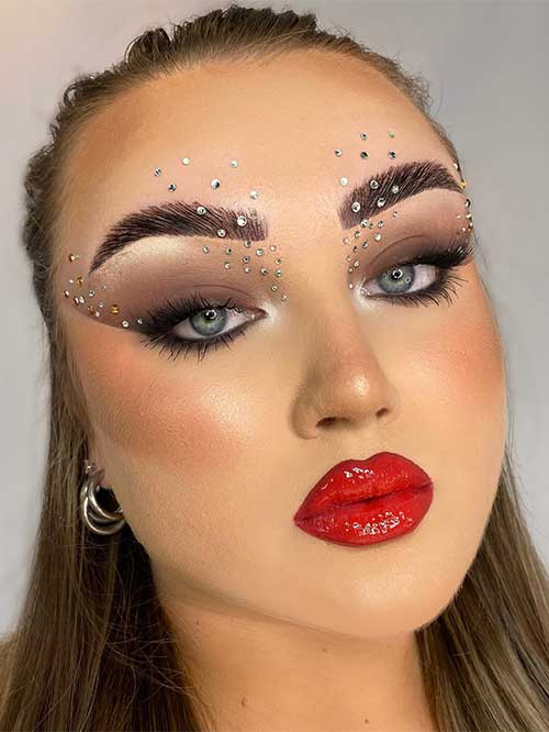 A creative rhinestone makeup look features Smokey eyes and black eyeliner