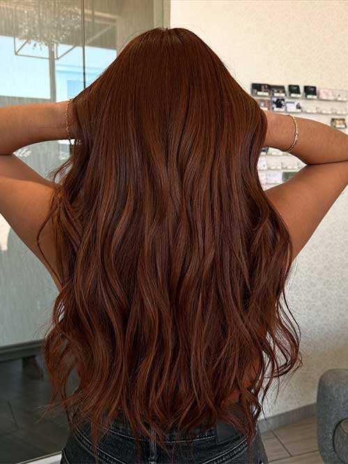 Long hair dyed in honey brown copper, reflecting the warm hues of the autumn season.