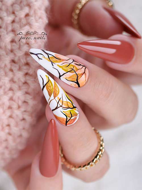 Elegant deep chestnut almond nails adorned with autumn leaf art on two white accent nails, reflecting a fall-inspired theme.