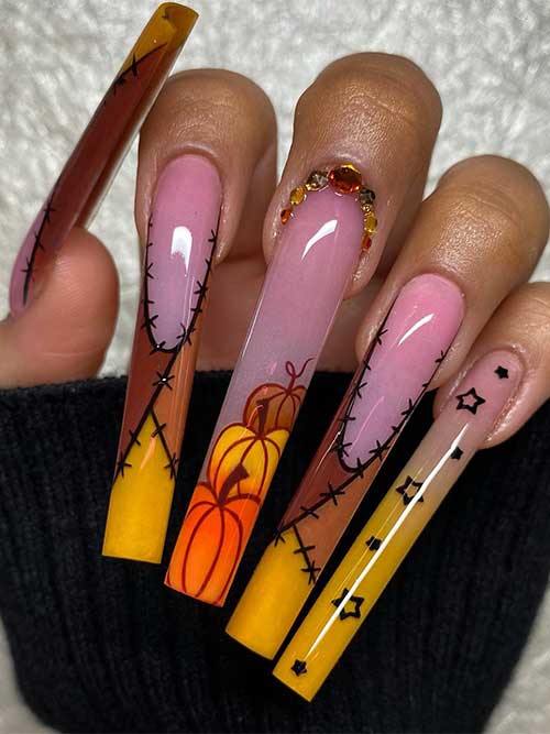 Long Spooky Fall Nails feature burnt yellow and brown French tips with pumpkins and rhinestones.