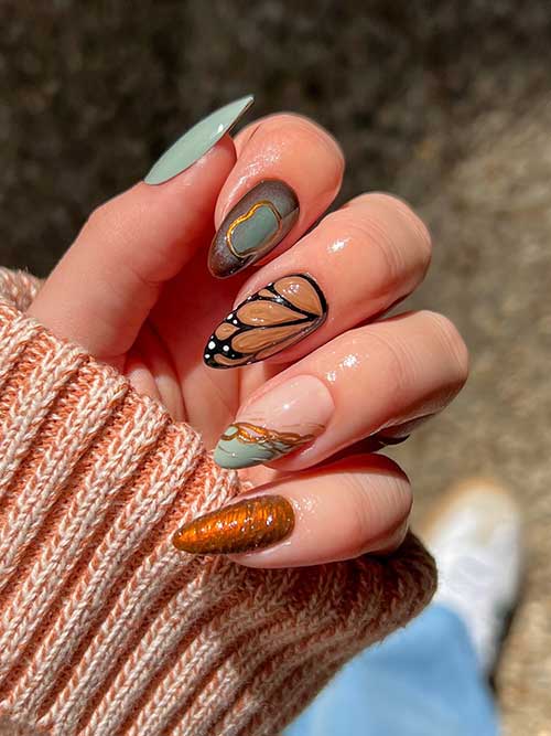 Long dusty blue-green September nails adorned with burnt pumpkin orange 3D gel and a butterfly accent in black and light brown.