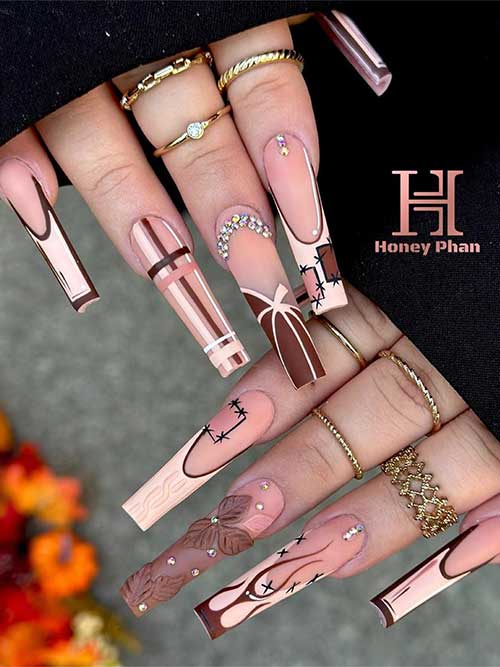 long comic brown and nude fall nails feature pumpkin, sweater, plaid, and 3d flowers adorned with rhinestones.
