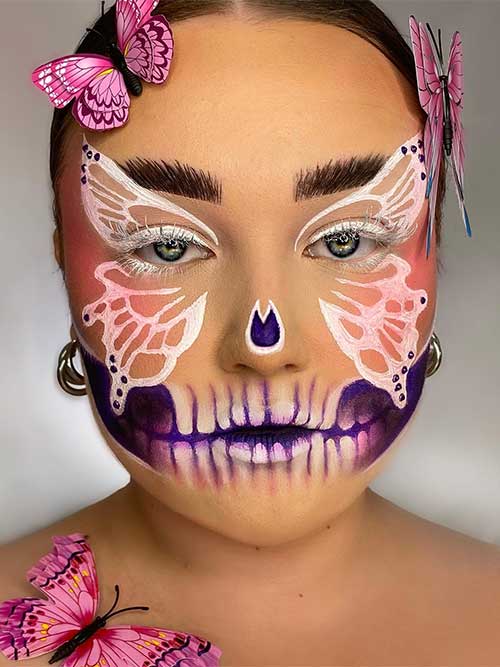 Butterfly Skull makeup with a big white butterfly covering eyes, nose, and cheeks with purple and white skull teeth