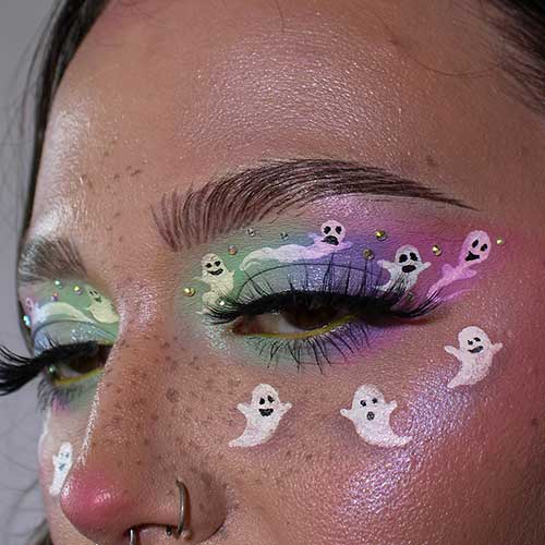 Ghost eye makeup features colorful eyeshadows with rhinestones and some ghosts on the upper lid and under the lower lid.