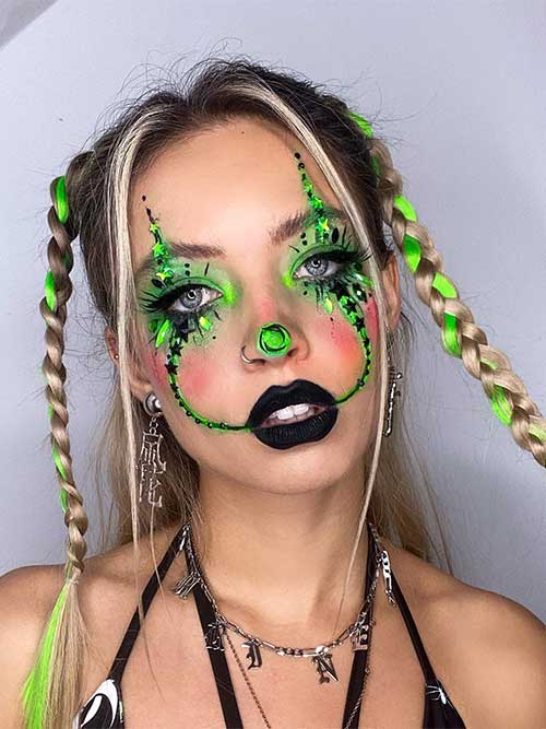 Neon green and black clown makeup with matte black lips, green rhinestones, and a touch of neon green color on hair braids