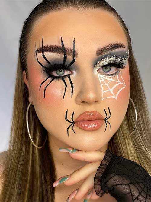 Spider eye makeup that features black smokey eyes and a black spider on an eye with a rhinestone on each leg