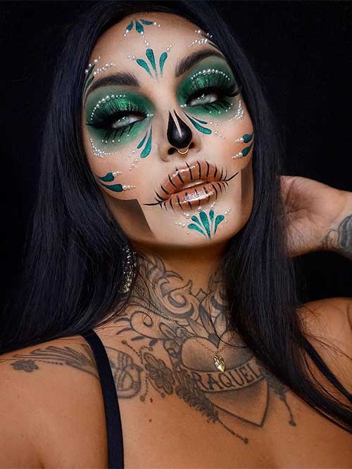 Stunning Catrina Halloween makeup using matte green eyeshadow with glitter on upper and lower eyelids, and long lashes