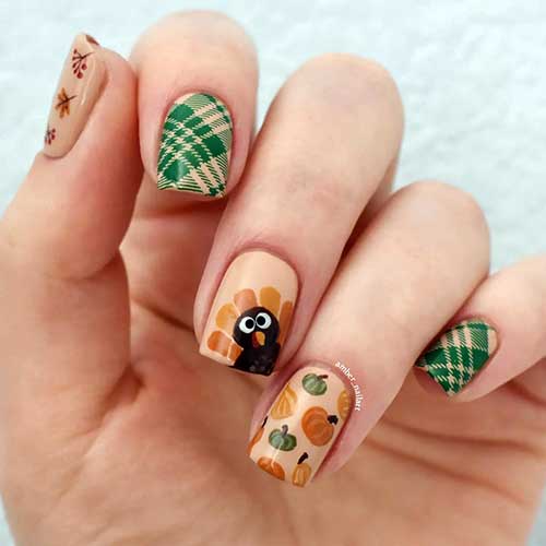 Short square beige Thanksgiving nails featuring green plaid art, turkey, maple leaves, and pumpkin accents on select nails.