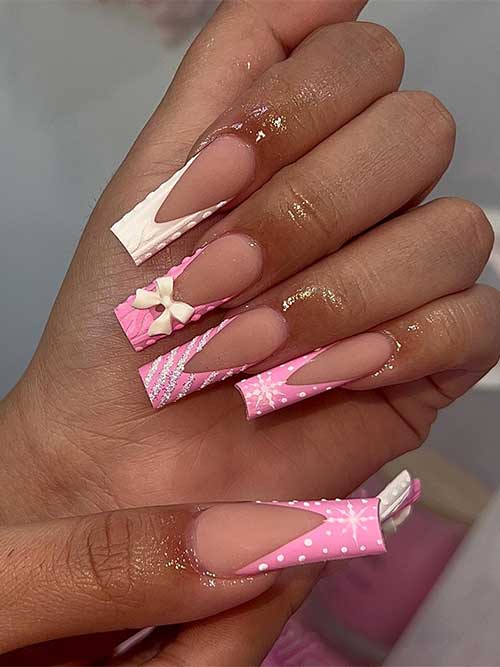 Long pink Christmas nails with v-shaped French tips adorned with candy cane nail art, snowflakes, and sweater nail art