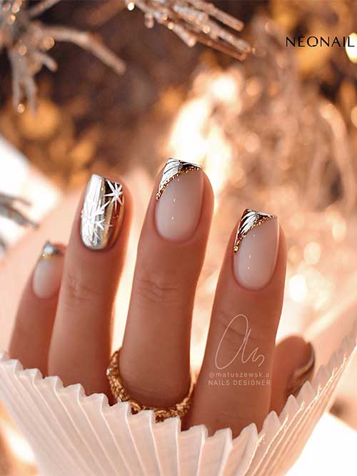 Short metallic gold Christmas nails with diagonal French tips and snowflake nail art