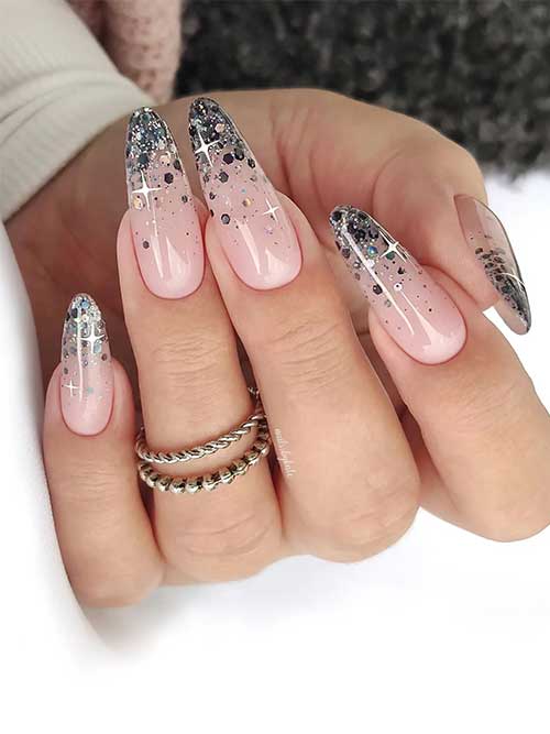 Classy almond-shaped glitter black ombre New Year’s nails using black glitter over a nude pink base color
