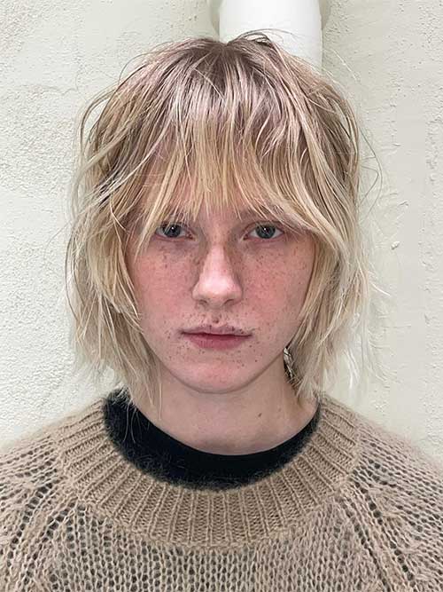 Face frame light blonde shaggy bob with bangs and dark roots