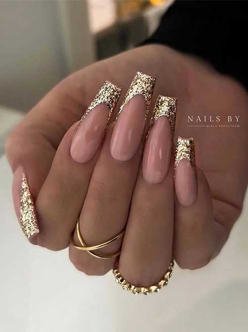 Long coffin-shaped gold glitter festive French manicure that suits New Year’s Eve