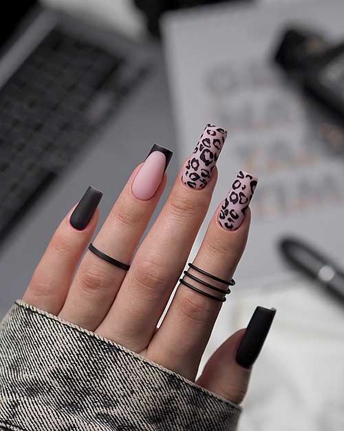 Matte black nails with two accent black leopard print nails over a nude pink base color and a black French tip nail