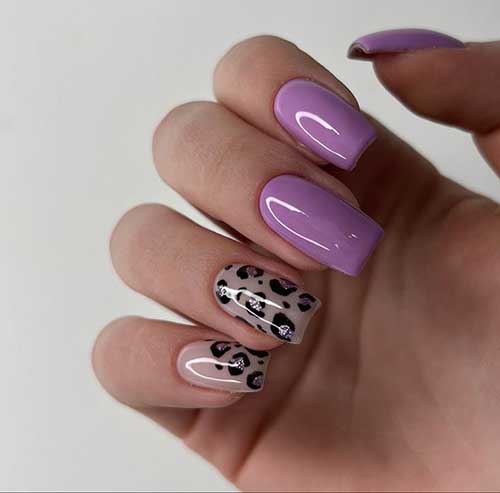 Medium square-shaped purple nails with two accent black with glitter leopard print nails over a nude base color