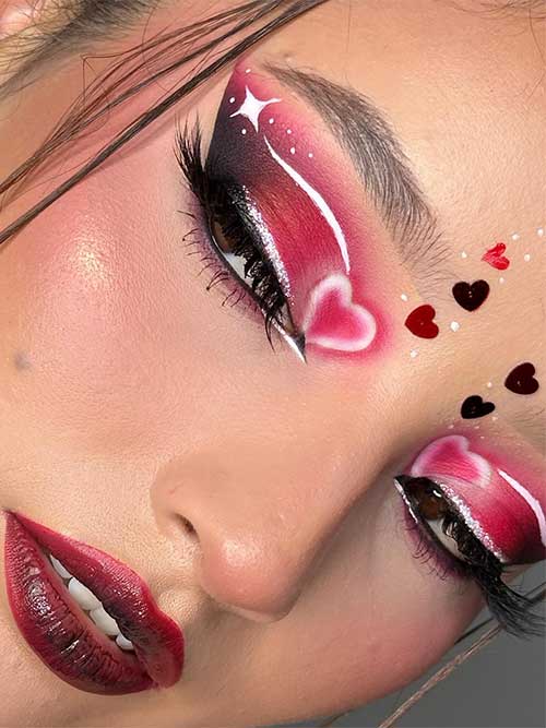 Red and black ombre Valentine’s makeup with white graphical eyeliner, gold glitter eyeliner, and red ombre lips