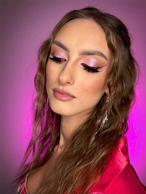 Shimmer pink Valentine’s Day makeup features shimmer pink eyeshadow on the eyelids, black winged eyeliner with rhinestones