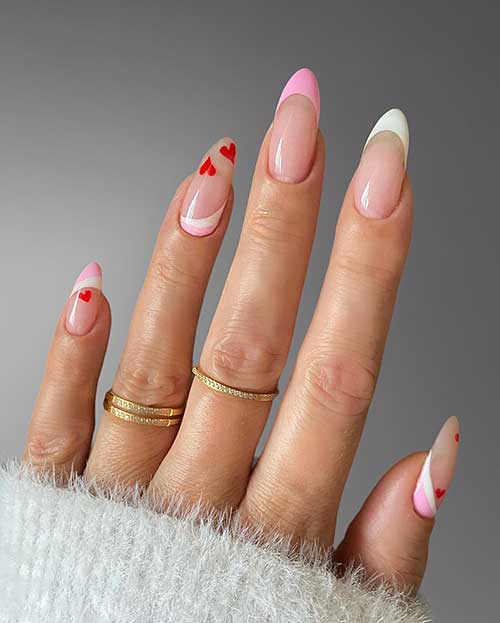 White and pink French nails with tiny red hearts and two accent nails feature a diagonal reversed French manicure