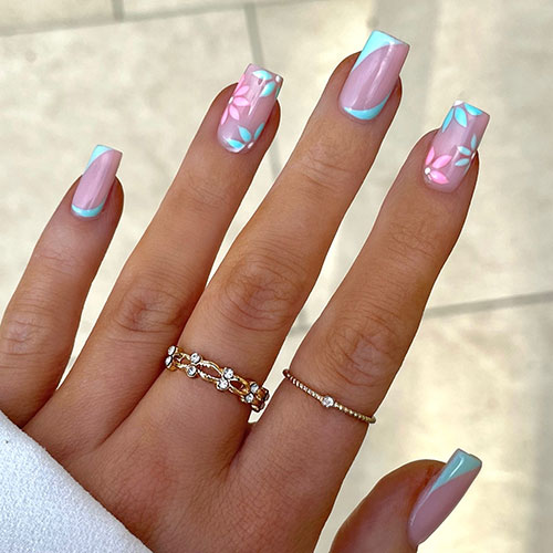  Aqua blue diagonal French tip nails with two nude nails adorned with pink and aqua blue flowers