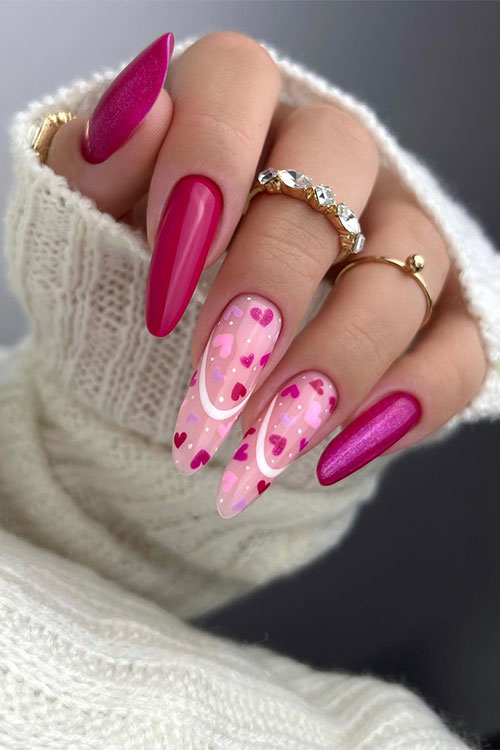 Hot pink Valentine's Day nails with glitter and two accent nude nails adorned with hearts and negative space French tips