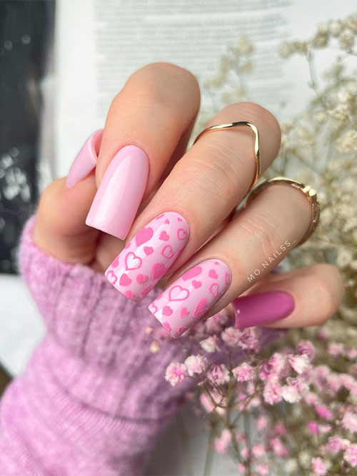 Long Light pink Valentine’s Day nails with candy pink heart shapes on two accent nails