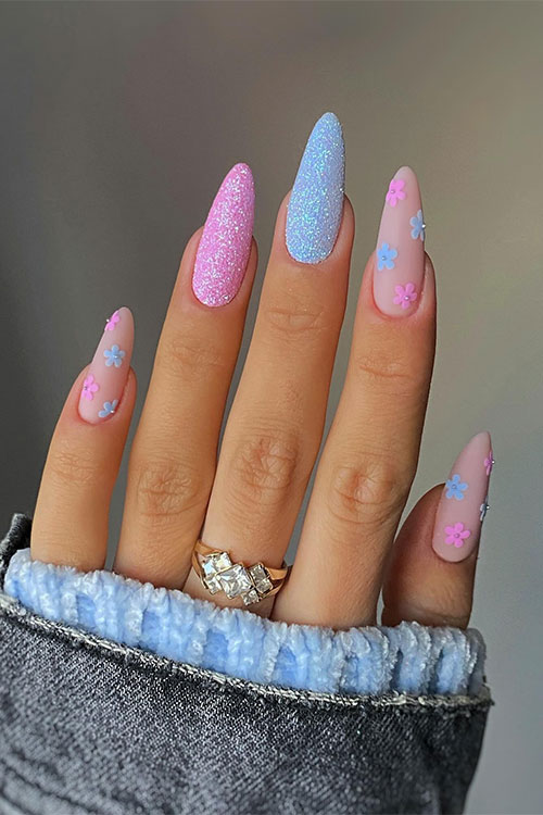 Pink and blue floral spring nail design features matte tiny blue and pink flowers over a nude base color