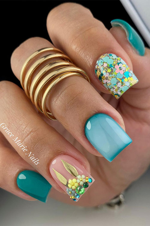 Short green Easter nails feature floral nail art on an accent glitter nail and a nude accent with flowers, and rhinestones