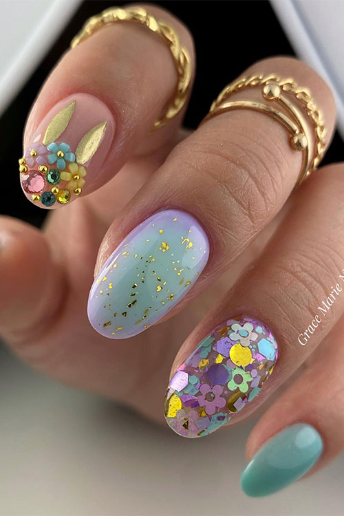 Short mint green Easter nails with a nude accent nail adorned with flowers, rhinestones, and gold bunny ears