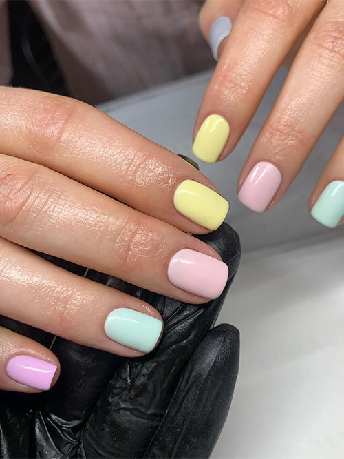 Cute multicolored pastel short spring nails feature blue, nude pink, pink, mint green, and yellow nail colors