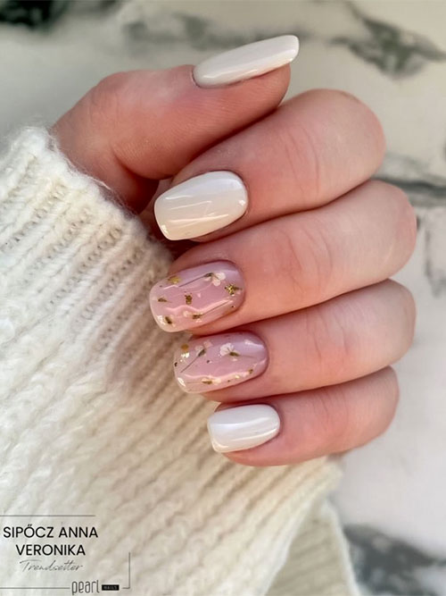 White short spring nails with delicate white blossoms on two accent nude pink accent nails adorned with gold foil