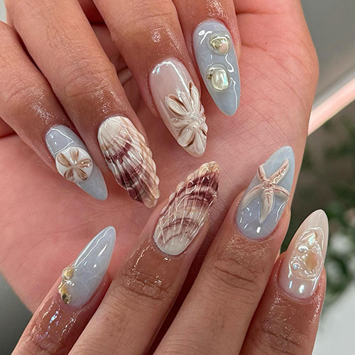Gray almond-shaped nails adorned with water effects and sea stars, a nude with brown seashell nails, and a nude pearl nail