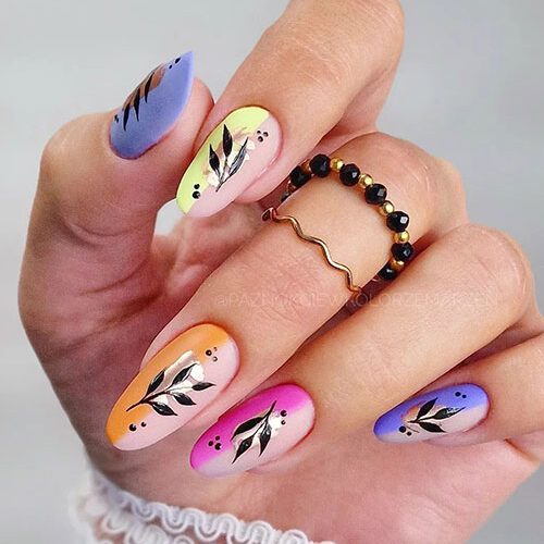 Matte multicolored negative space nails with a touch of foil and a black leaf nail art and dot nail art