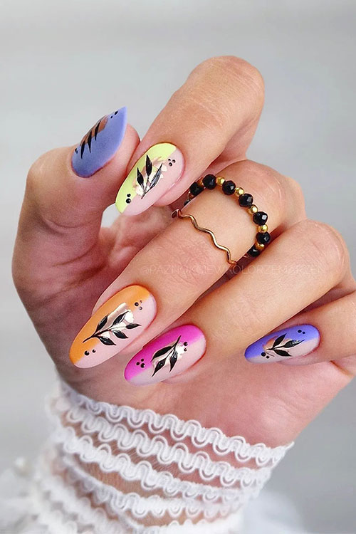 Matte multicolored negative space nails with a touch of foil and a black leaf nail art and dot nail art