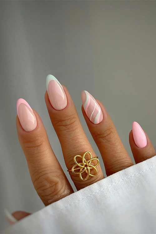 Medium almond-shaped pink and mint green pastel French nails with an accent swirl nail and a solid pastel pink accent nail