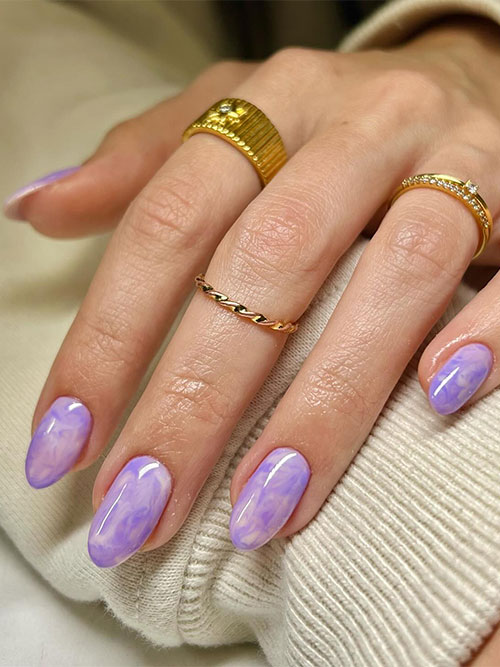 Medium almond-shaped purple marble pastel nails over a nude base color