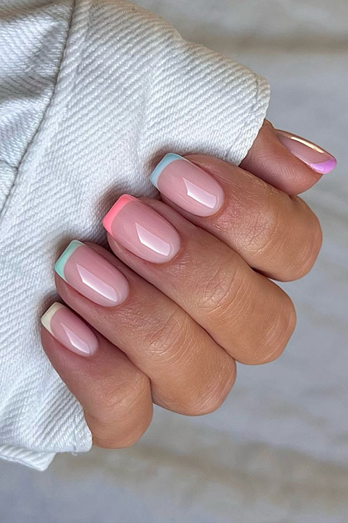 Multicolored French pastel nails feature blue, purple, yellow, orange, and green pastel nail colors