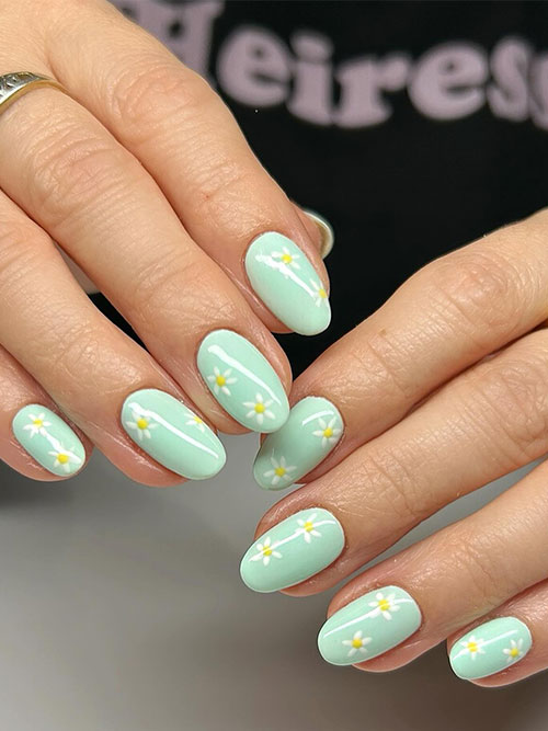 Pastel green nails with daisies