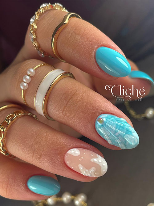 Short light blue nails with a seashell accent nail adorned with a pearl and two accent sea stars and water droplets nails