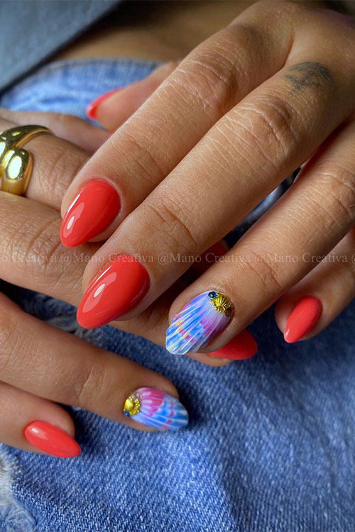 Short red nails adorned with an accent blue seashell nail adorned with a touch of pink and some gold seashell rhinestones