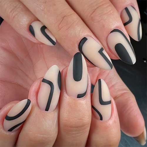 Almond-shaped matte black abstract nails over a nude base color