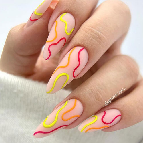 Cute long almond-shaped nude nails adorned with neon yellow, neon orange, and neon strawberry swirls