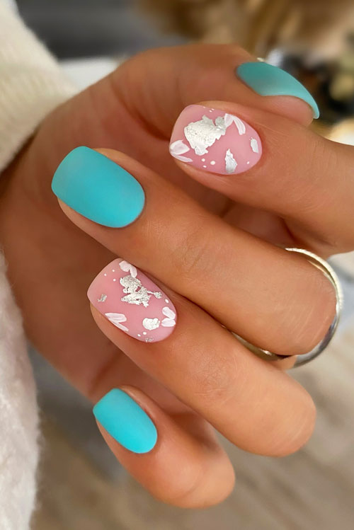 Cute matte turquoise nails short length with two nude accents adorned with silver foil flakes and white abstract nail art