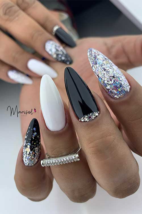 Long almond-shaped black summer nails with white and silver glitter accent nails and some rhinestones on the ring fingernail