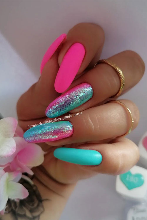 Long almond-shaped matte neon pink nails with an aqua blue accent and two ombre pink to aqua blue nails adorned with glitter