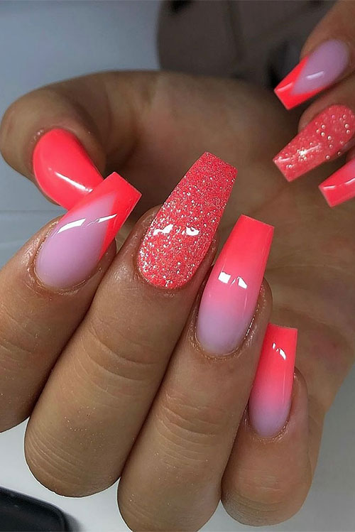 Long coffin neon orange nails that feature an ombre style on two accent nails and an accent nail adorned with sugar glitter