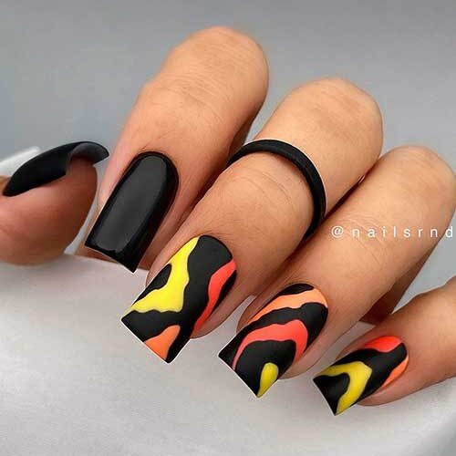 Long square-shaped black summer nails adorned with neon peach, orange, and yellow abstract nail art