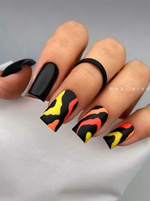 Long square-shaped black summer nails adorned with neon peach, orange, and yellow abstract nail art