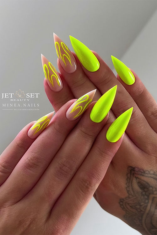 Long stiletto neon green nails with neon yellow flame nail art on two accent nude nails